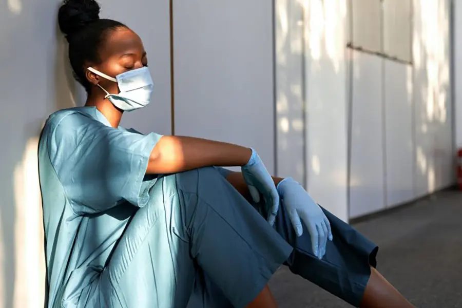 exhausted healthcare worker sitting on floor